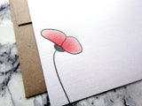 Letterpress lone poppy in red and black, half-tone, on white cards with brown envelopes, designed and printed by inviting in Austin, Texas.