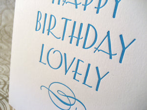 Letterpress birthday card reads "Happy Birthday Lovely" and has an elegant flourish.
